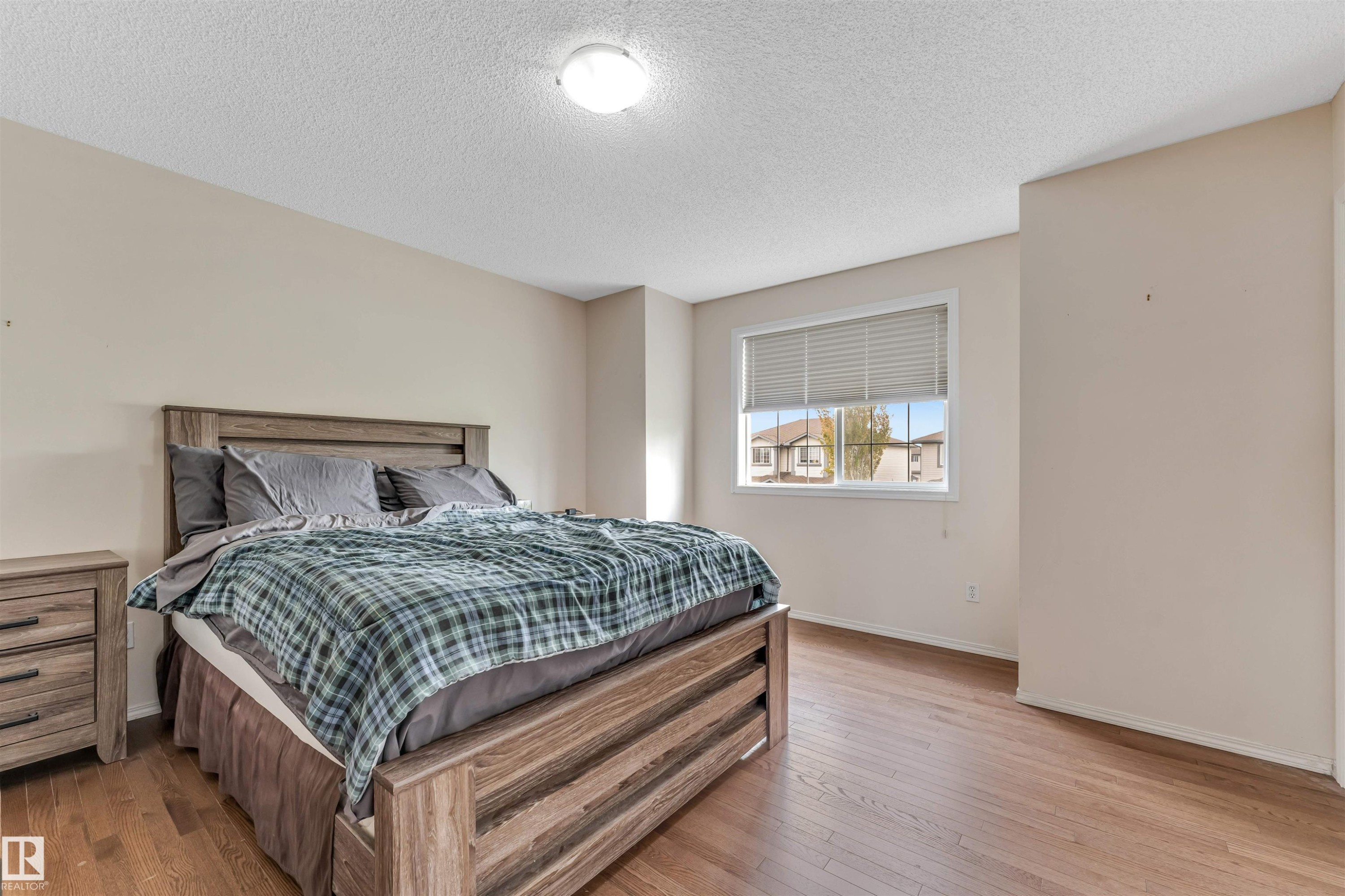 Bedroom featuring wood-finish flooring, a neutral color palette, and a window with horizontal blinds - 3032 31 Avenue, Edmonton, AB - Indoor Photo Showing Bedroom