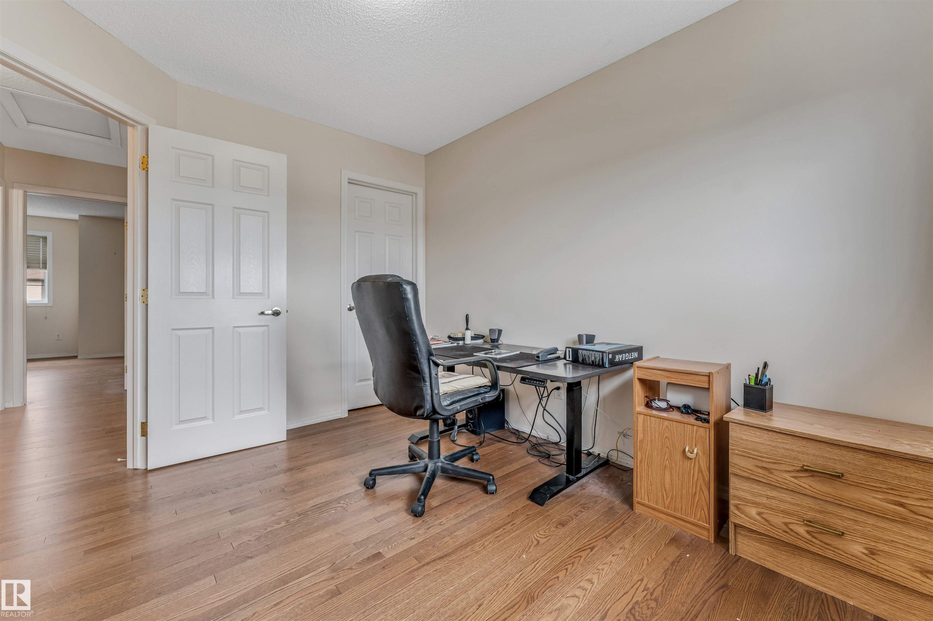 Room featuring wood-finish flooring, light-toned wall paint, and white paneled doors - 3032 31 Avenue, Edmonton, AB - Indoor Photo Showing Office