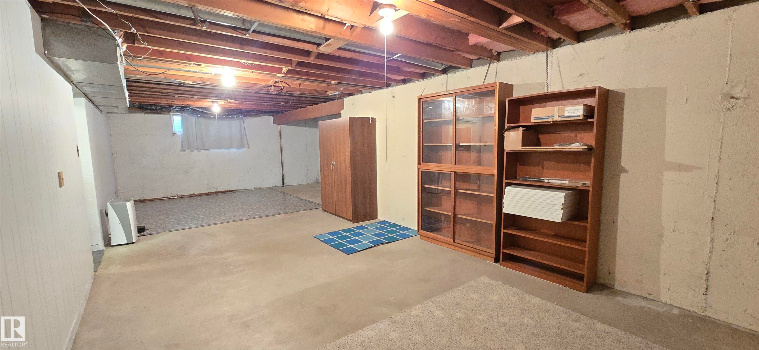 Unfinished basement with exposed ceiling joists and concrete flooring - 5304 49 Street, Two Hills, AB - Indoor Photo Showing Basement
