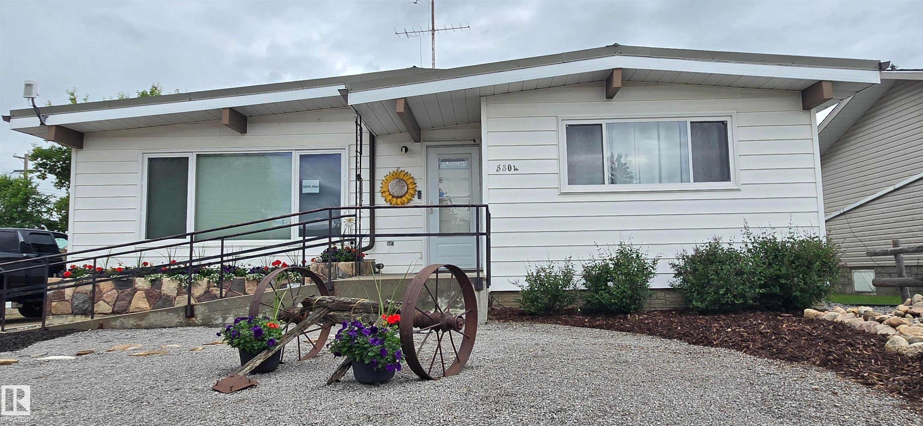 White horizontal siding exterior with a gravel driveway - 5304 49 Street, Two Hills, AB - Outdoor With Exterior