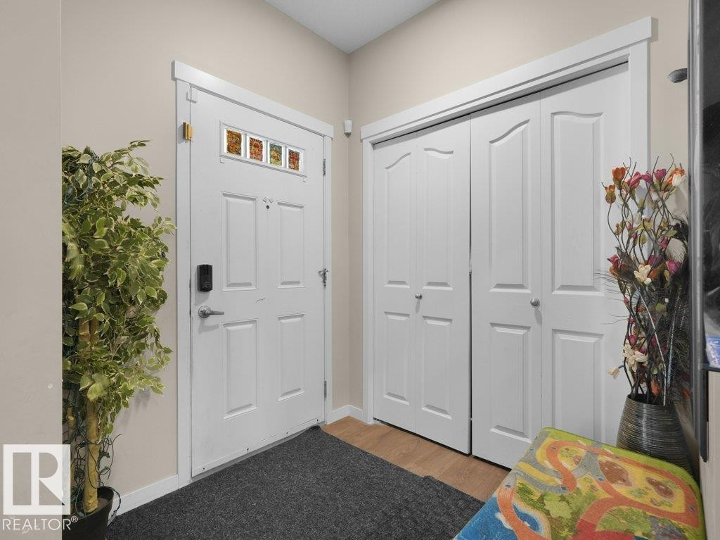 Entryway featuring a paneled door with decorative glass accents and a digital lock - 1419 27 Av, Edmonton, AB