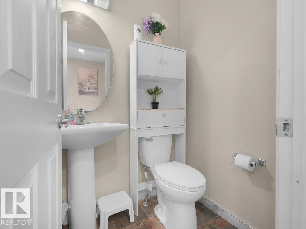 Pedestal sink with a chrome faucet and an oval wall-mounted mirror - 1419 27 Av, Edmonton, AB