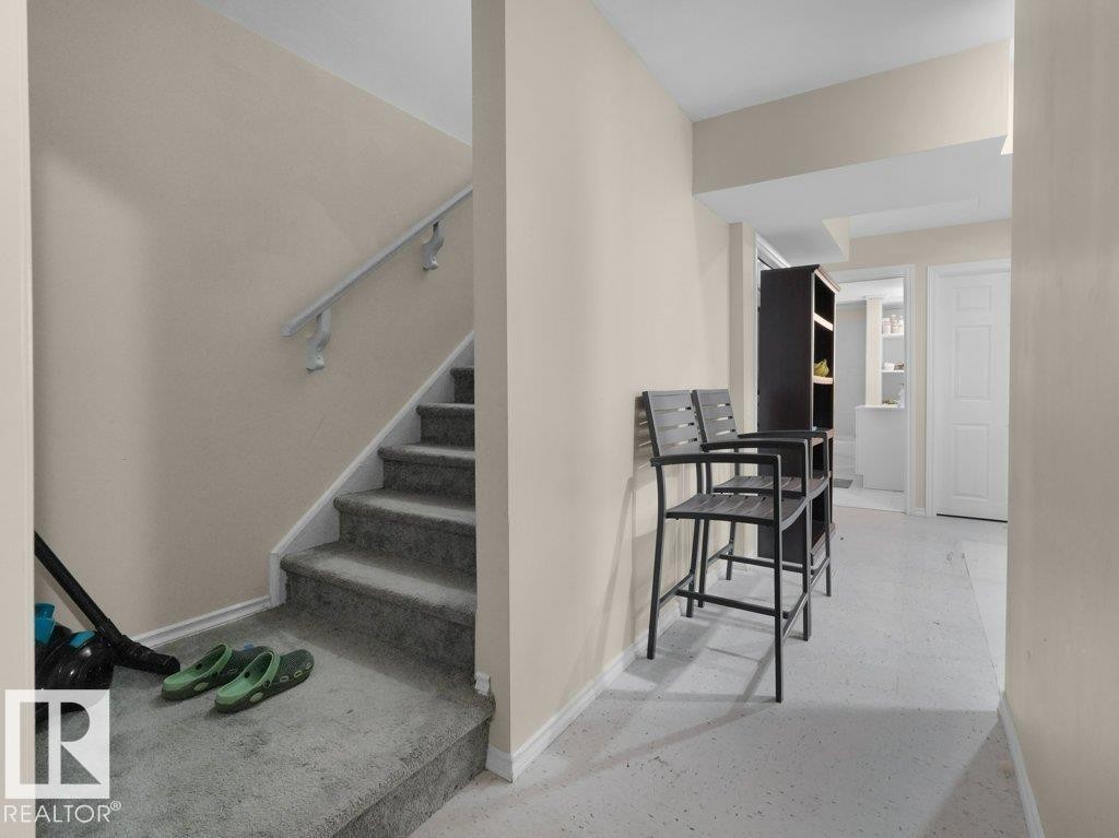 Carpeted staircase with white handrail and base trim - 1419 27 Av, Edmonton, AB