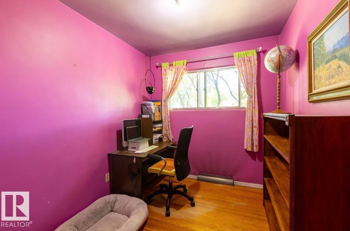 Room featuring wood-finish flooring and a large window - 8719 67 Avenue Nw, Edmonton, AB - Indoor Photo Showing Office