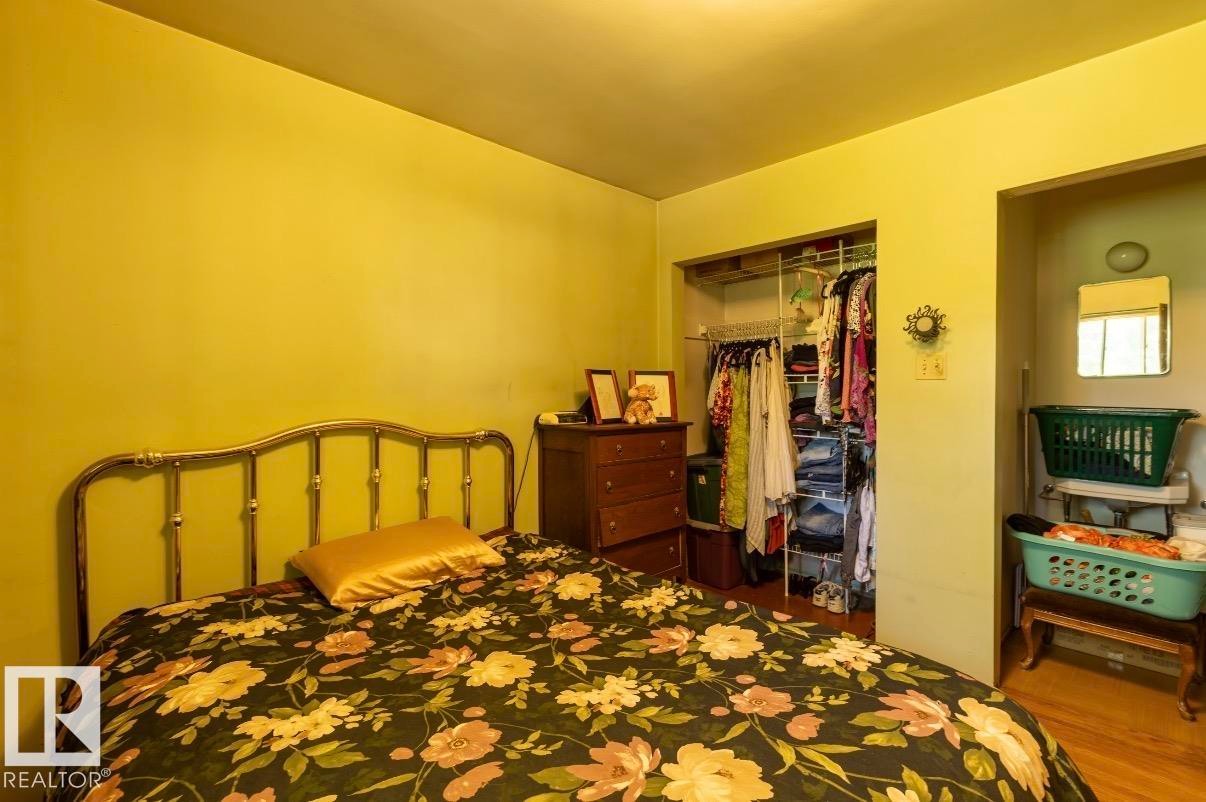 Bedroom featuring a built-in closet with shelving and hanging rods - 8719 67 Avenue Nw, Edmonton, AB - Indoor Photo Showing Bedroom