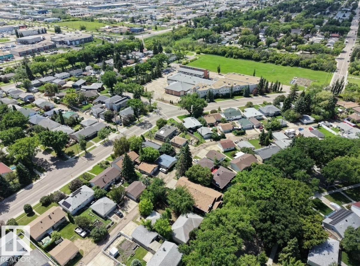 Aerial perspective showcasing a residential neighborhood with mature trees, established streets, and varied single-story and multi-story homes - 8719 67 Avenue Nw, Edmonton, AB - Outdoor With View