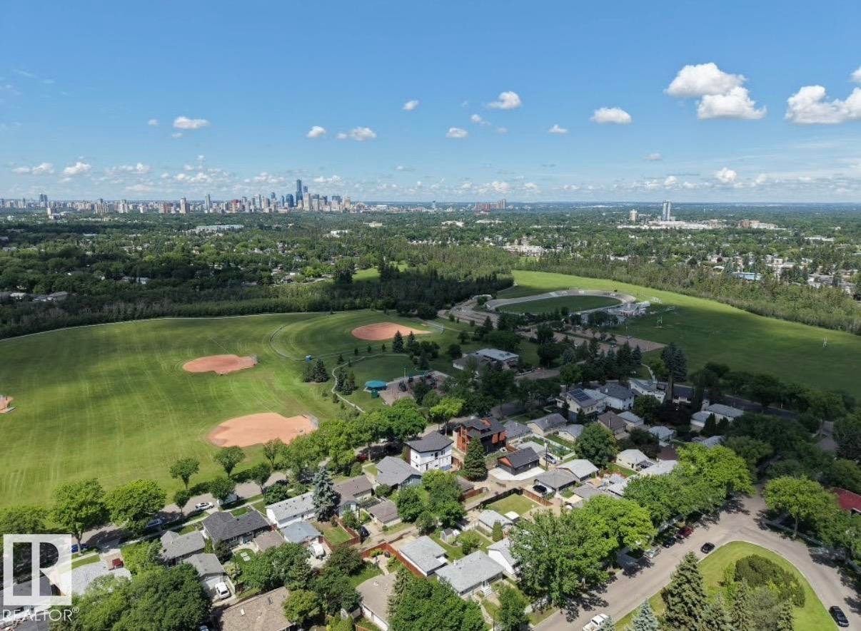 Aerial perspective showcasing a residential neighborhood with verdant trees and manicured green spaces - 8719 67 Avenue Nw, Edmonton, AB - Outdoor With View