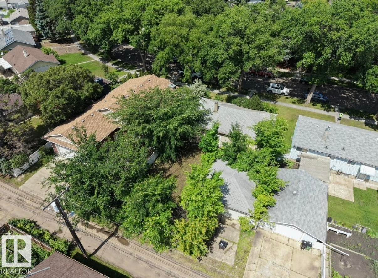 Brown shingle roof home with attached two-car garage and concrete driveway - 8719 67 Avenue Nw, Edmonton, AB - Outdoor