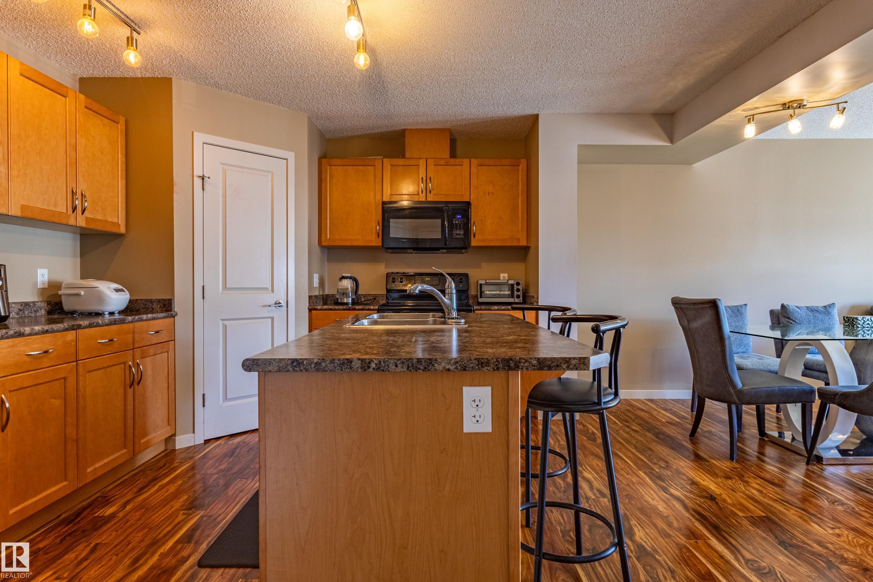 Wood-finish flooring throughout the kitchen and dining area - 13 1816 Rutherford Road, Edmonton, AB
