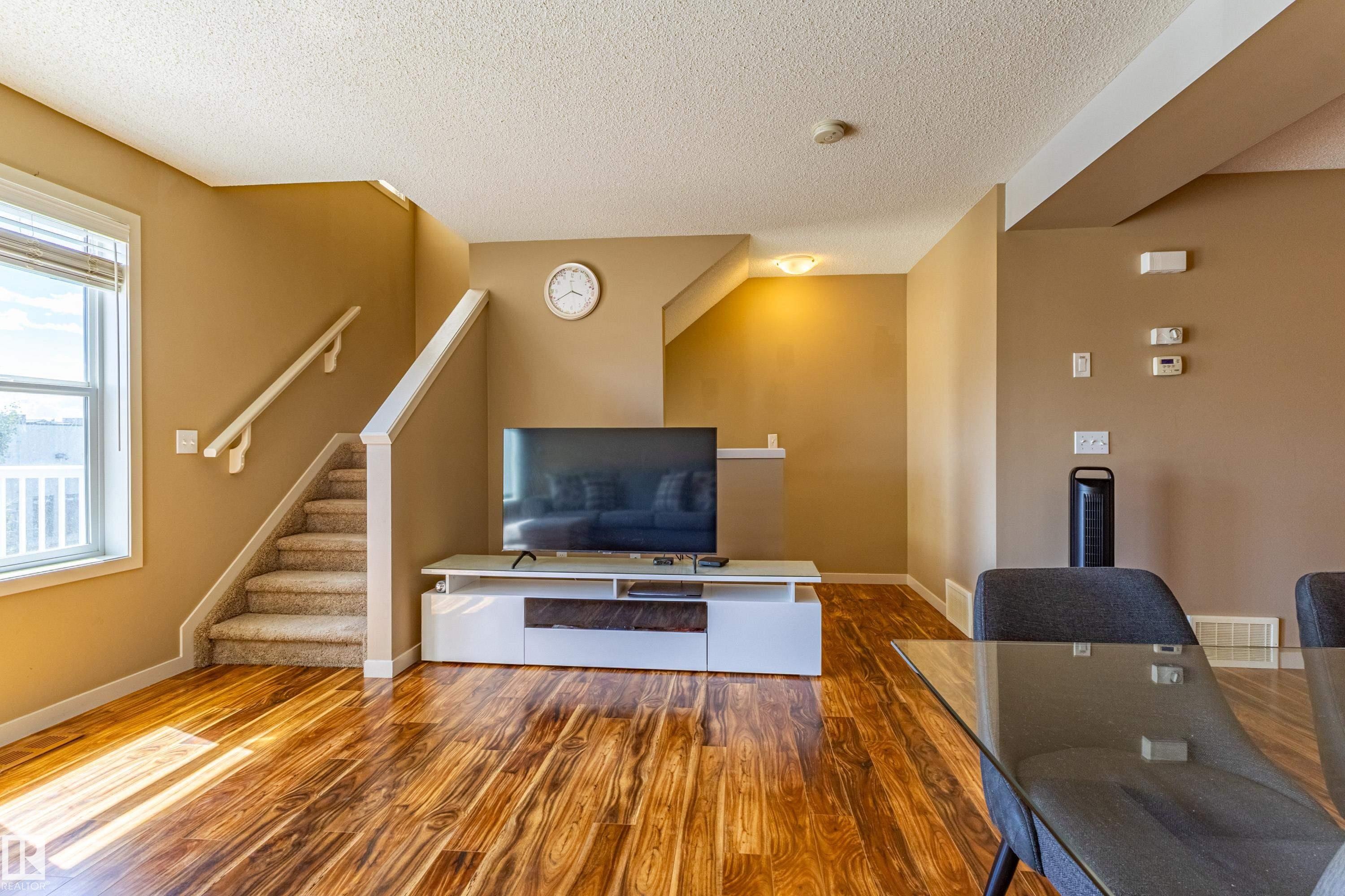 Warm wood-finish flooring complements the neutral wall tones - 13 1816 Rutherford Road, Edmonton, AB