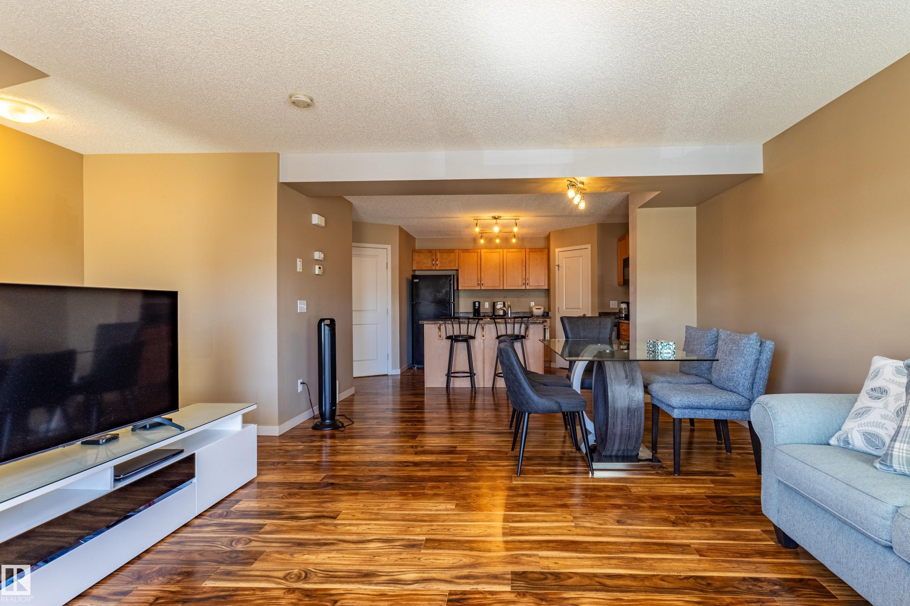 Open concept living area featuring wood-finish flooring throughout - 13 1816 Rutherford Road, Edmonton, AB