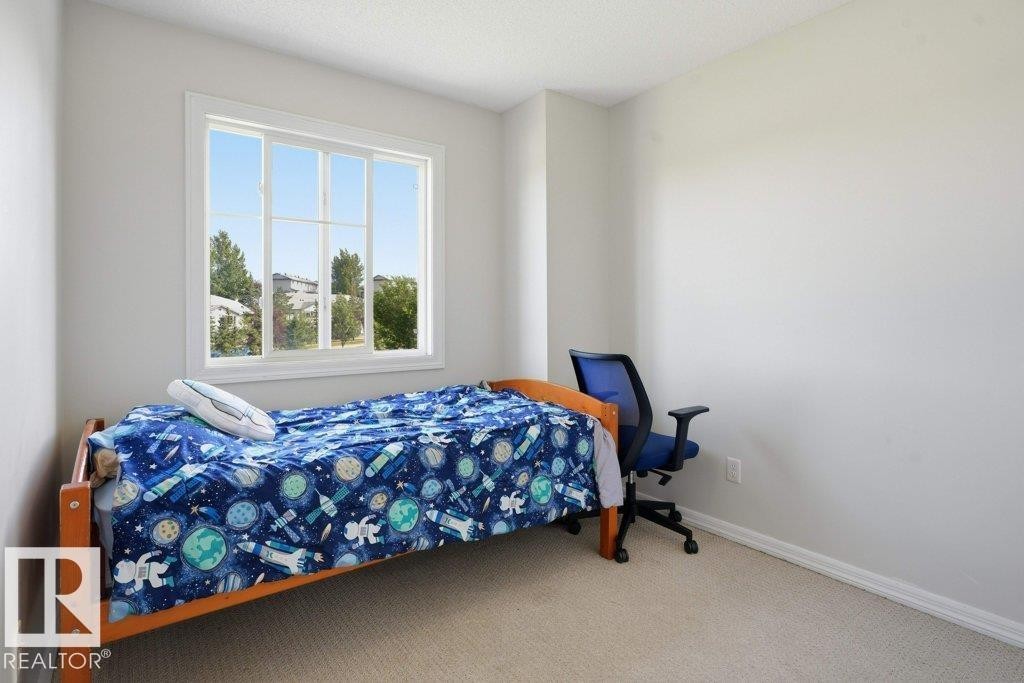 Neutral wall paint in a light tone, white baseboards, and carpeted flooring - 30 1404 Hermitage Road, Edmonton, AB