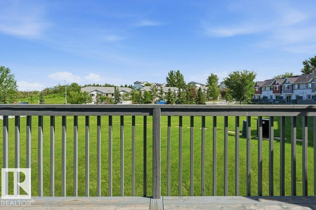 Deck railing with a wooden top rail and vertical balusters - 30 1404 Hermitage Road, Edmonton, AB