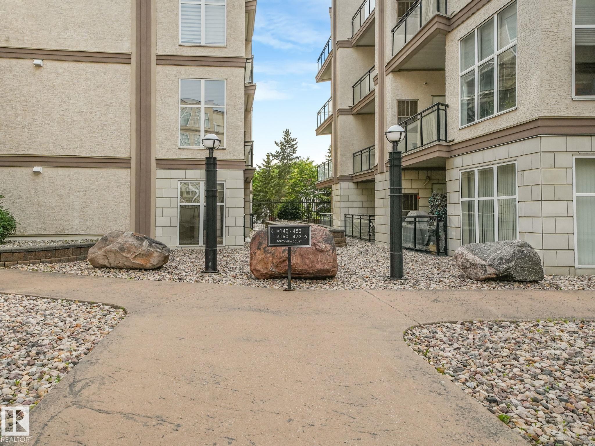 Modern apartment complex exterior featuring stucco siding with stone accents - 150 4827 104A Street, Edmonton, AB