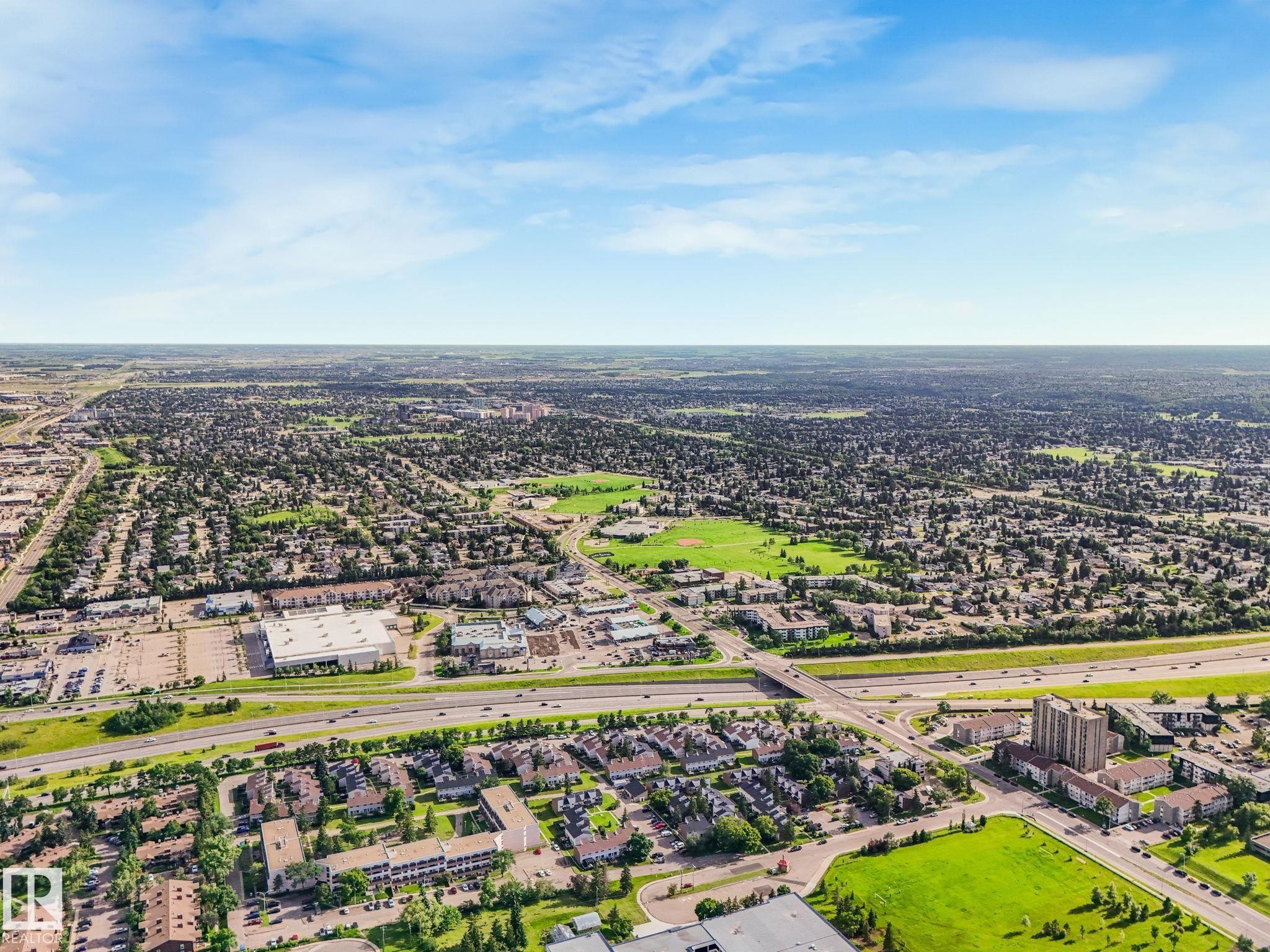 Expansive aerial view showcasing a developed urban landscape with diverse residential and commercial structures - 150 4827 104A Street, Edmonton, AB