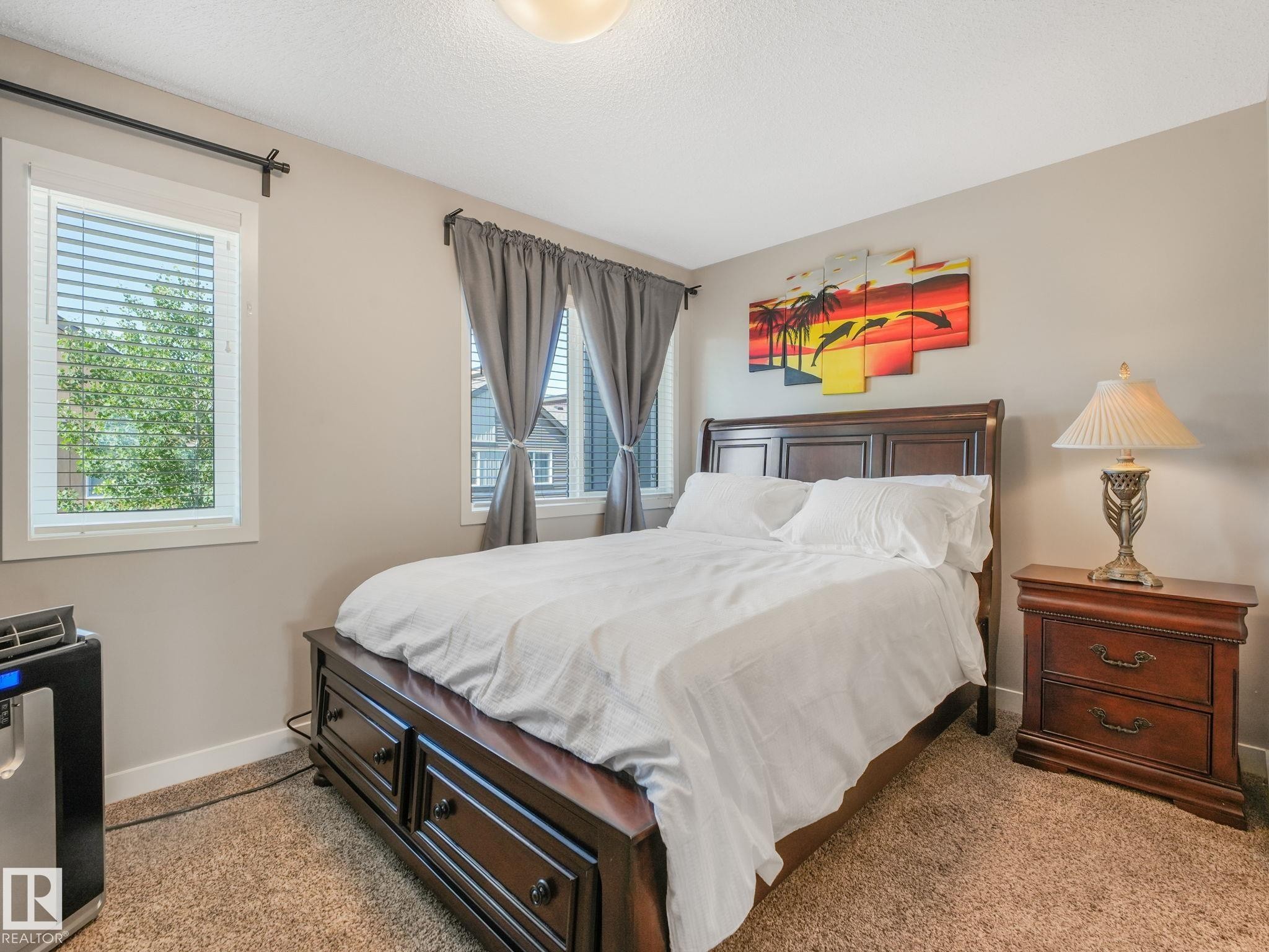 Bedroom featuring two windows with blinds, neutral wall paint, and carpet flooring - #55 4470 Prowse Rd Sw, Edmonton, AB - Indoor Photo Showing Bedroom