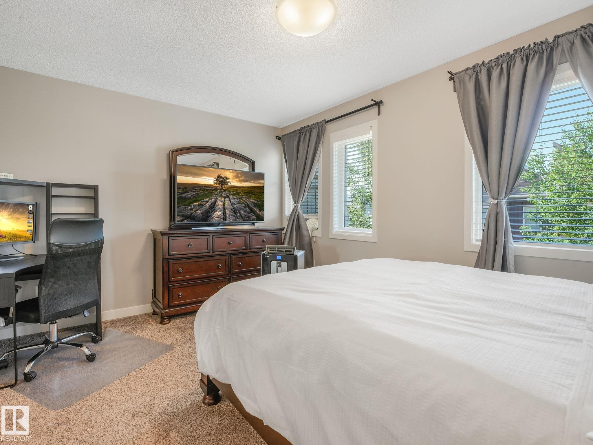 Bedroom featuring neutral wall paint, carpet flooring, and two windows with blinds - #55 4470 Prowse Rd Sw, Edmonton, AB - Indoor Photo Showing Bedroom