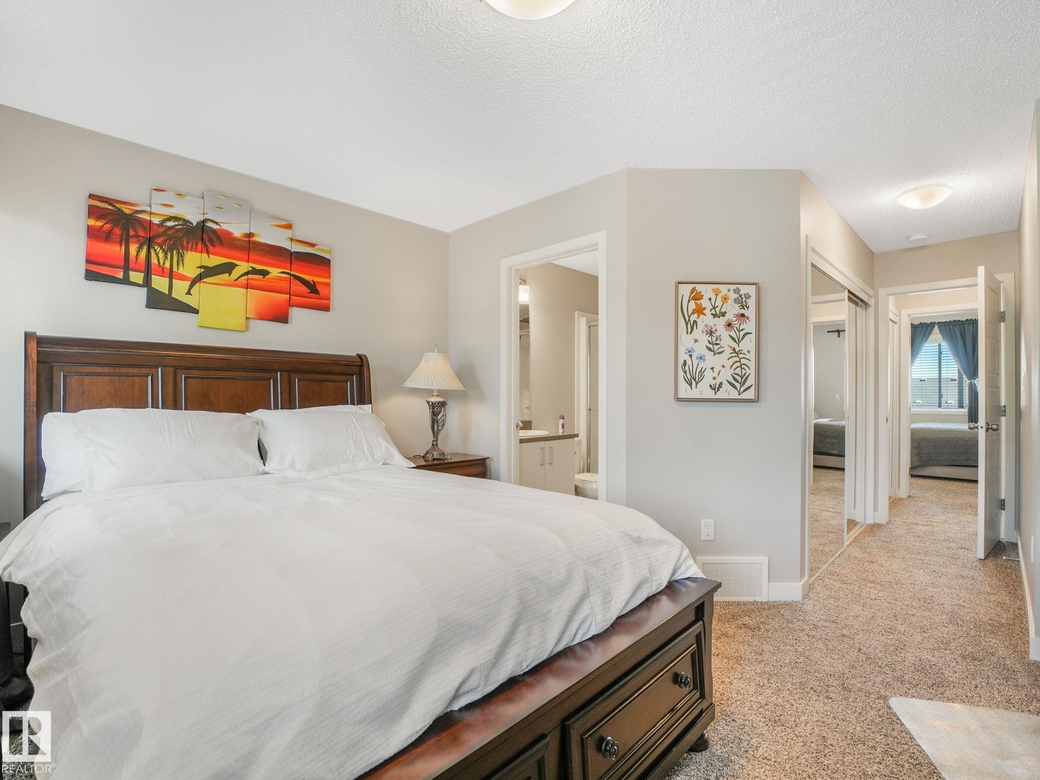 Carpeted room featuring a dark wood bed frame, a built-in closet with mirrored doors, and an overhead flush-mount light fixture - #55 4470 Prowse Rd Sw, Edmonton, AB - Indoor Photo Showing Bedroom
