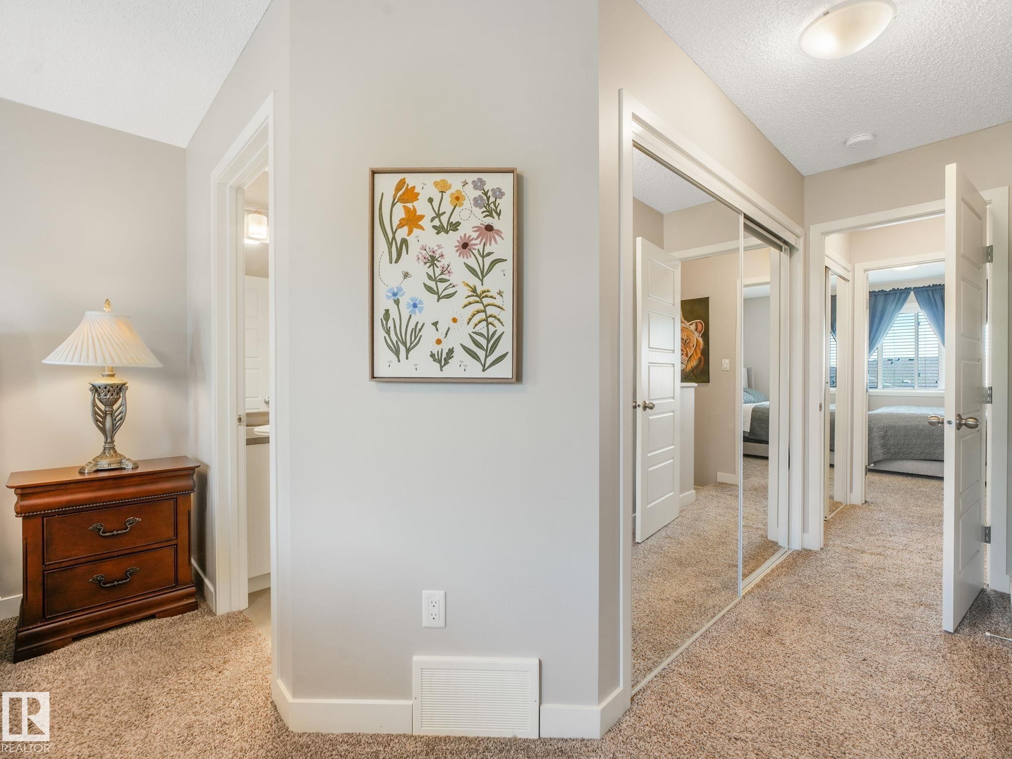 Hallway featuring neutral carpet flooring, light gray wall paint, white trim, and white interior doors - #55 4470 Prowse Rd Sw, Edmonton, AB - Indoor