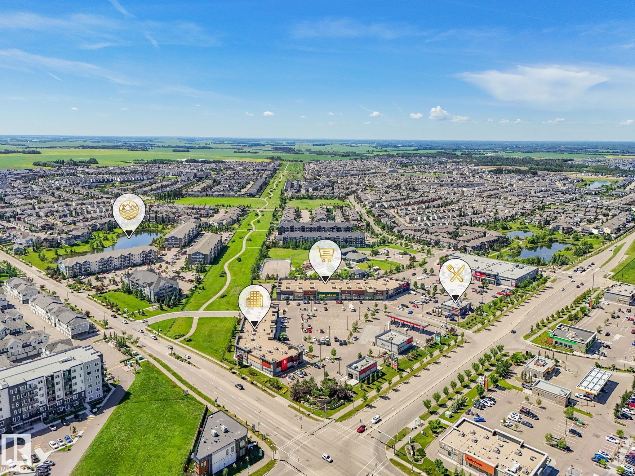 Aerial perspective showcasing a developed community with residential areas, commercial establishments, and green spaces - #55 4470 Prowse Rd Sw, Edmonton, AB - Outdoor With View
