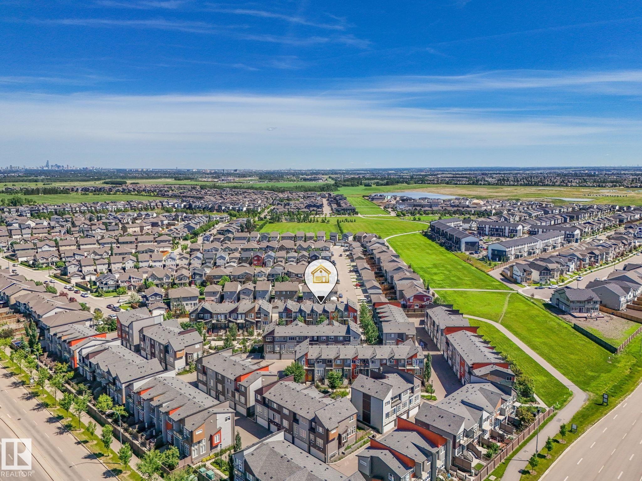 Aerial perspective of a developed residential community with rows of multi-story townhomes and single-family residences - #55 4470 Prowse Rd Sw, Edmonton, AB - Outdoor With View