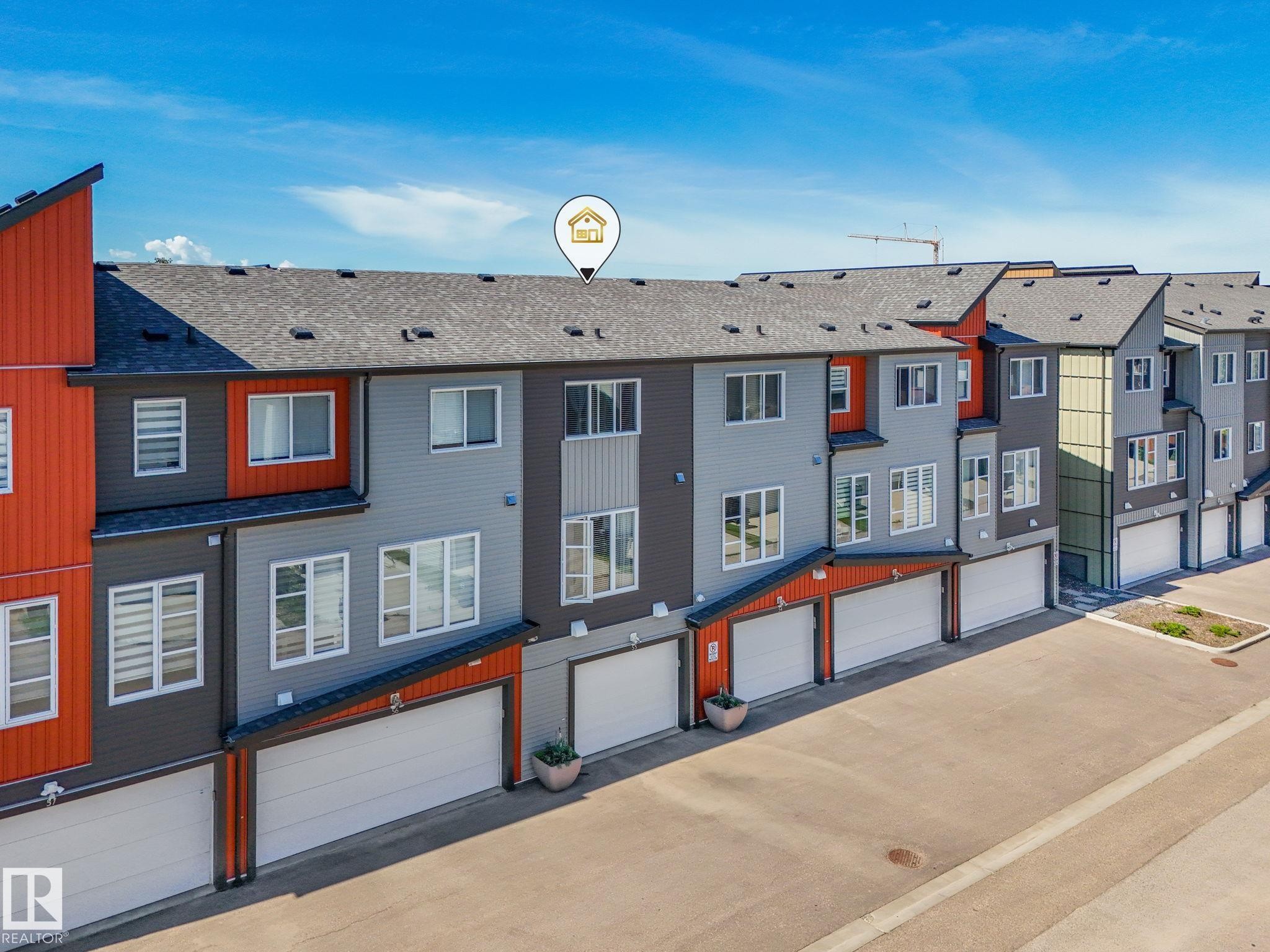 Modern multi-story townhome featuring a neutral color palette with vibrant orange accents - #55 4470 Prowse Rd Sw, Edmonton, AB - Outdoor