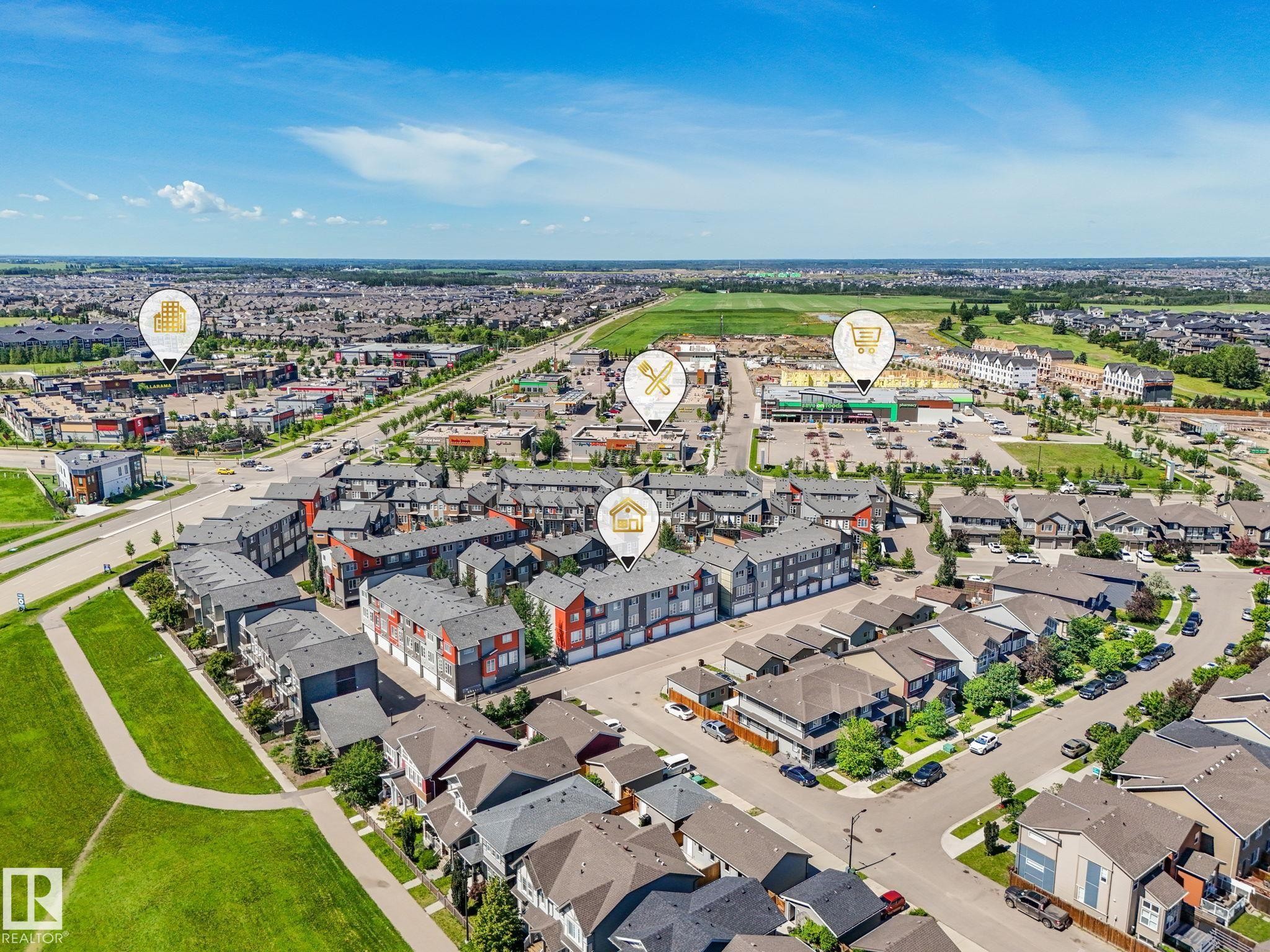 Aerial perspective showcasing a residential area with diverse housing styles, including multi-story townhomes and detached residences - #55 4470 Prowse Rd Sw, Edmonton, AB - Outdoor With View