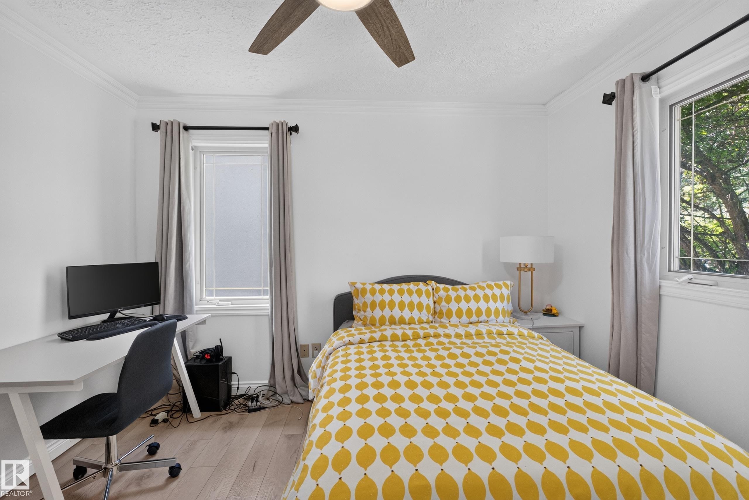 Bright room featuring wood-finish flooring and two windows with natural light - 11015 122 Street, Edmonton, AB