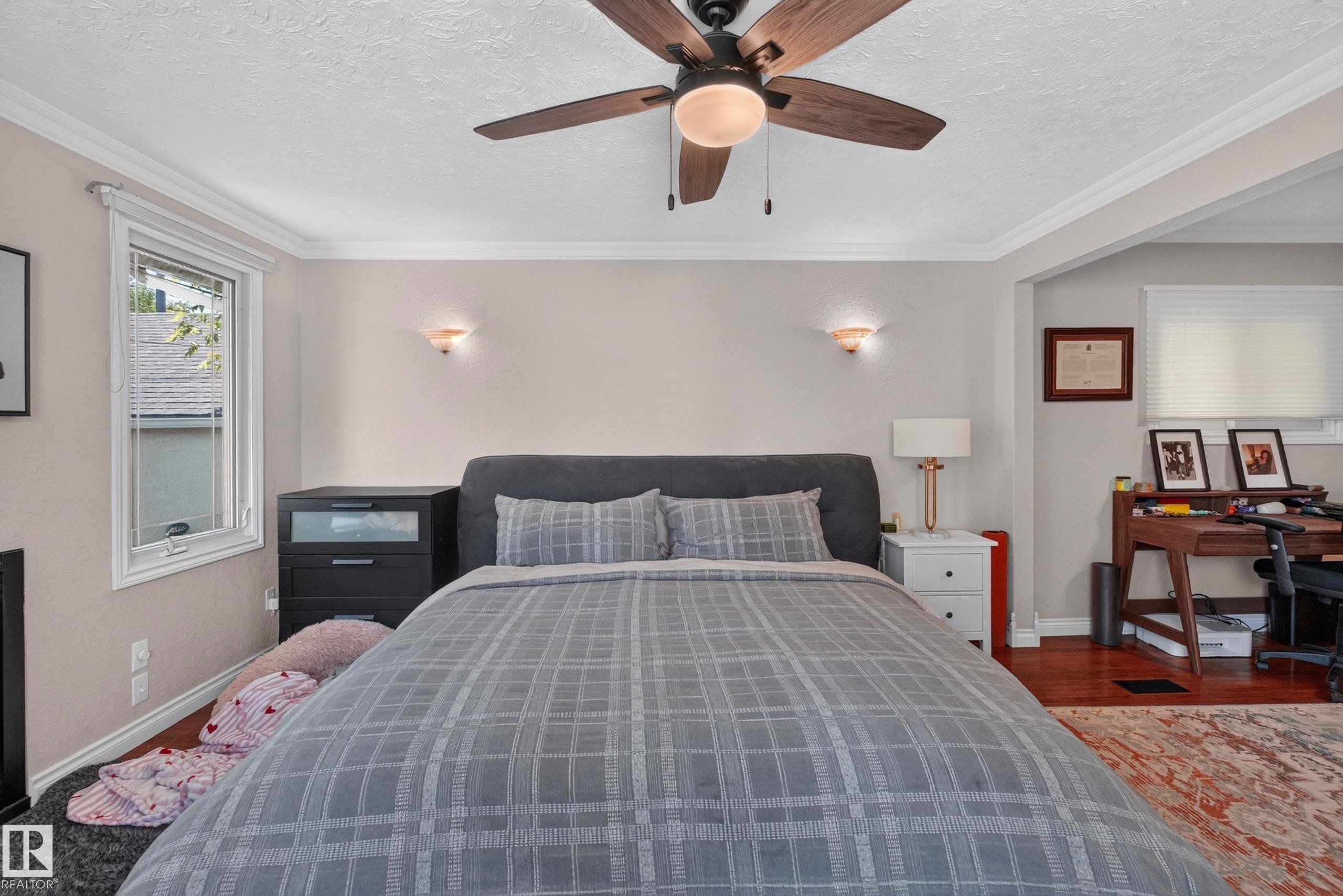 Ceiling fan with wooden blades, crown molding, wall-mounted sconces, and hardwood flooring - 11015 122 Street, Edmonton, AB