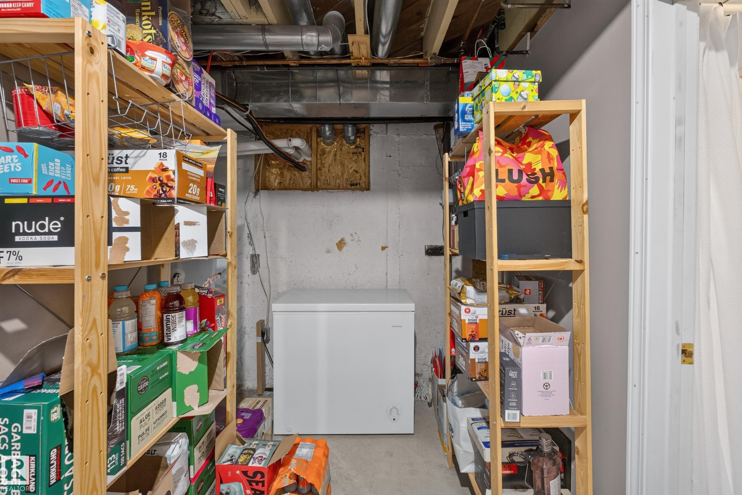 Unfinished basement area featuring exposed ceiling joists and ductwork, a concrete floor, and painted concrete walls - 11015 122 Street, Edmonton, AB