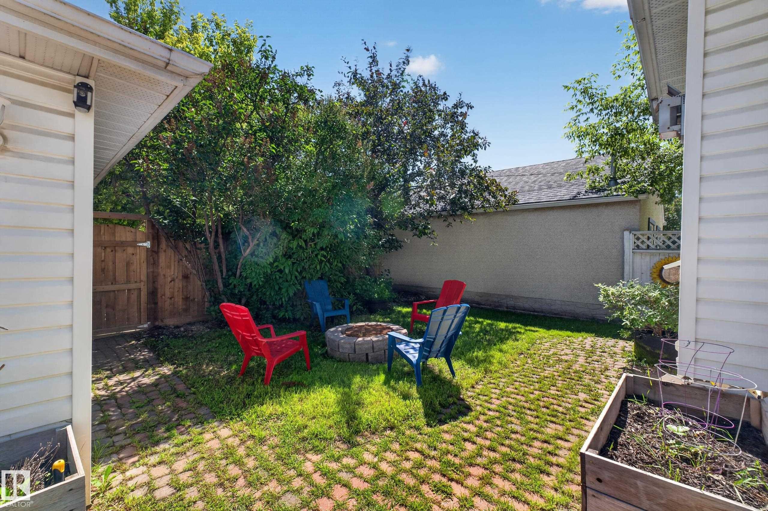 Private backyard featuring a paver patio and a built-in stone fire pit - 11015 122 Street, Edmonton, AB