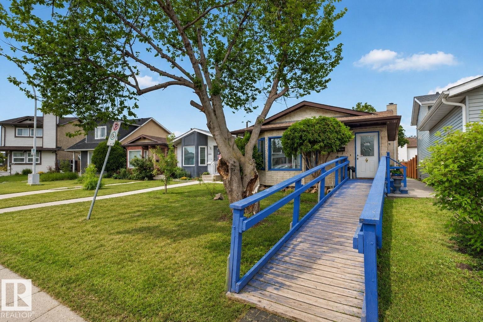Ranch-style exterior with a wood access ramp and blue railings - 8316 157 Avenue, Edmonton, AB