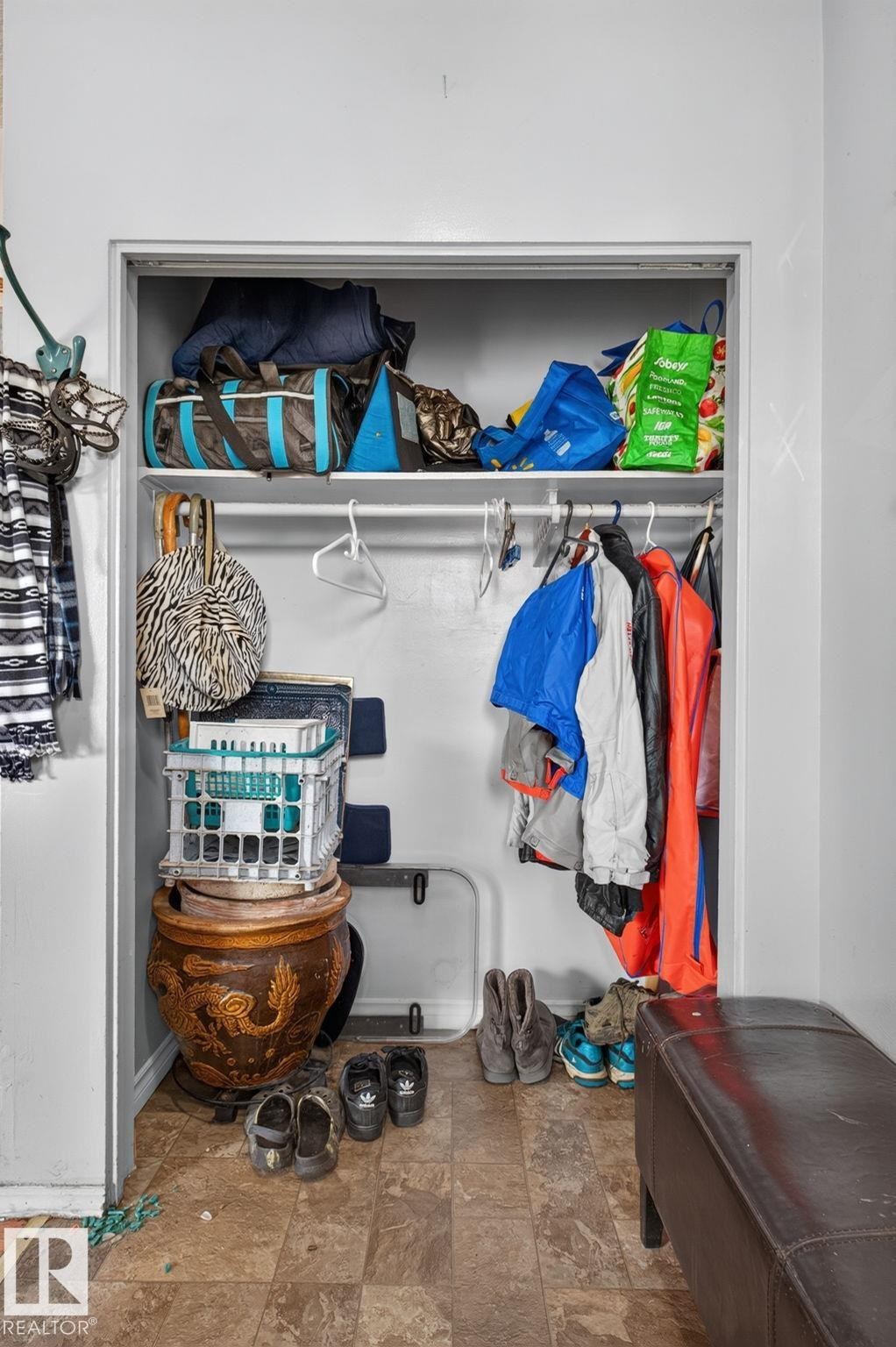 Built-in closet with overhead shelving, a clothing rod, and tiled flooring - 8316 157 Avenue, Edmonton, AB