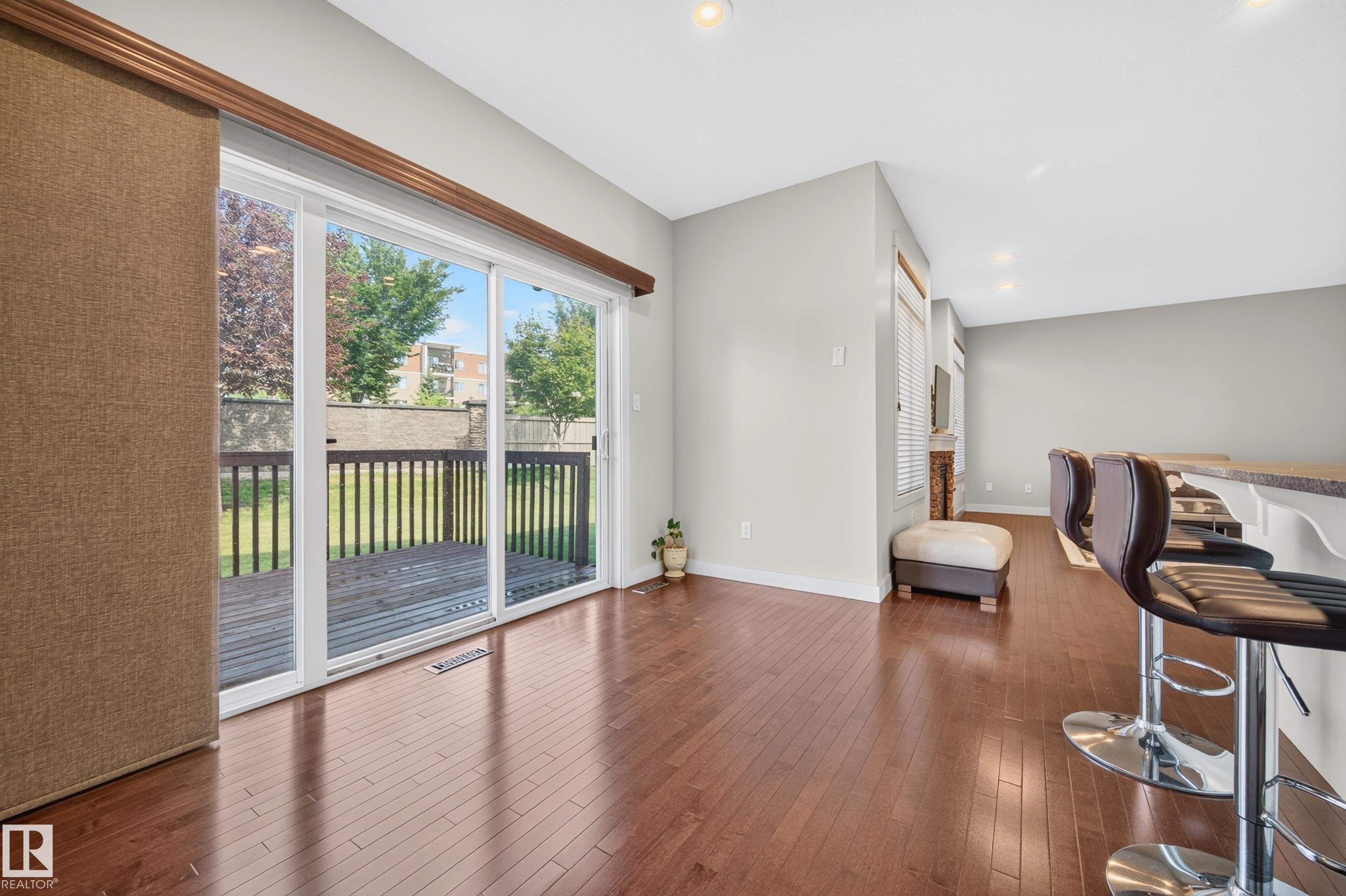 Hardwood-finish flooring extending from the living area to a spacious outdoor deck - 1512 Cunningham Cape, Edmonton, AB