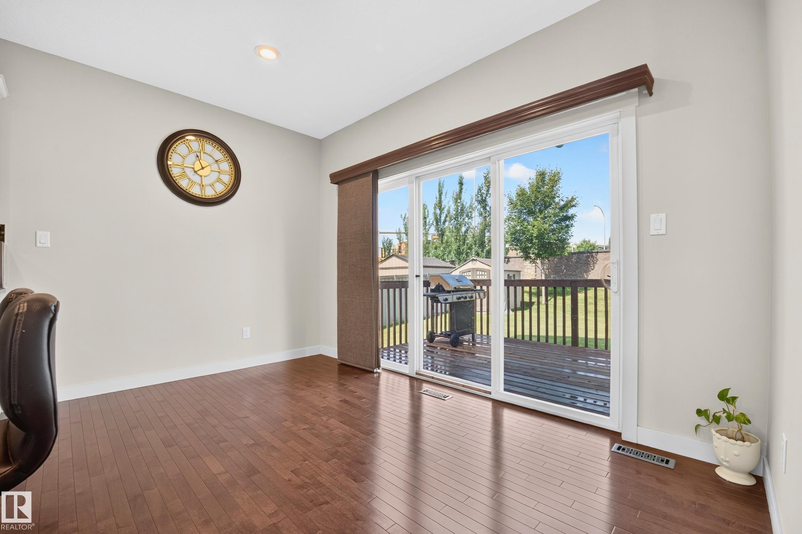 Sliding glass doors opening to an exterior wood deck - 1512 Cunningham Cape, Edmonton, AB
