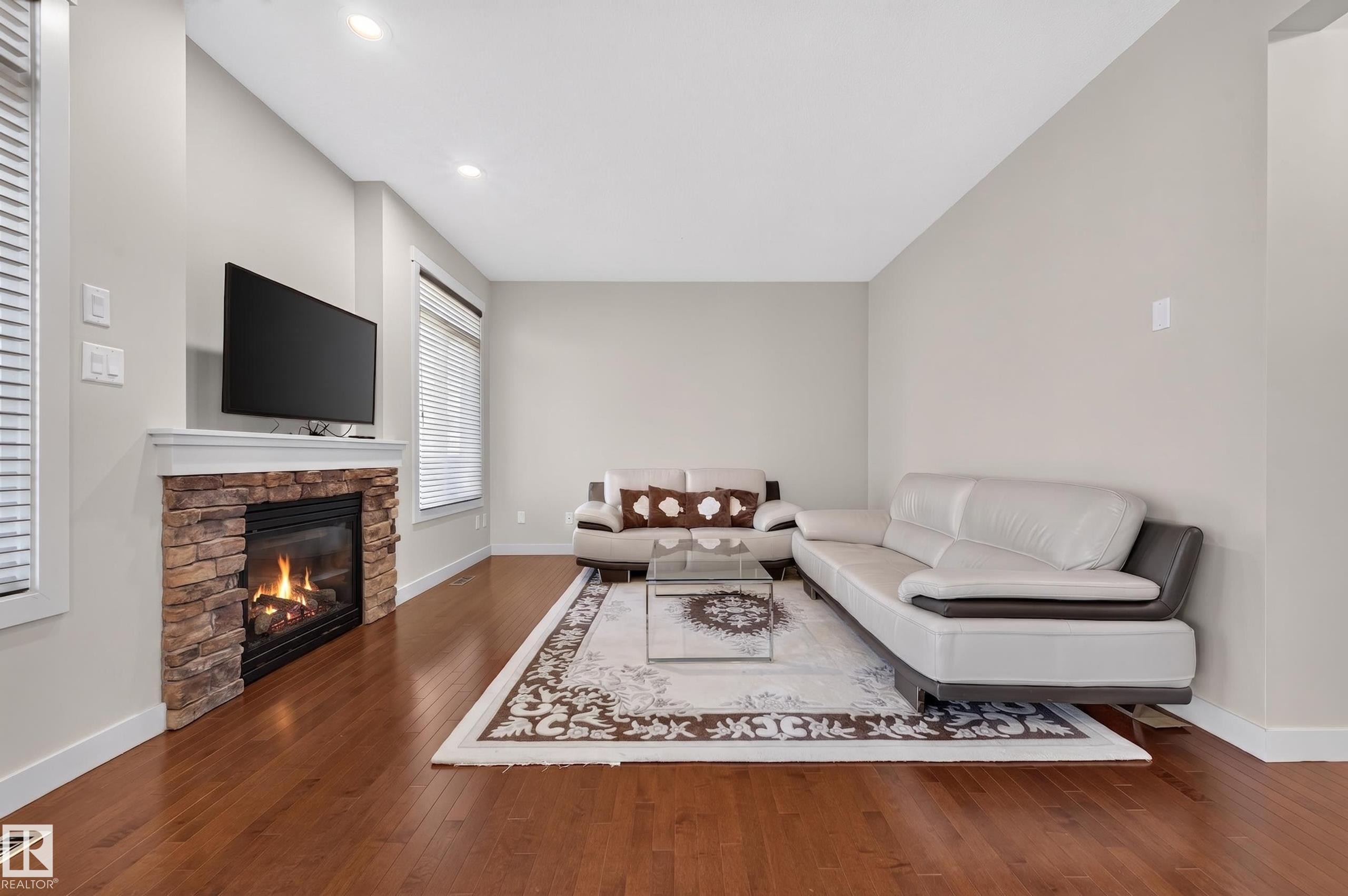 Living area featuring wood-finish flooring and light-toned walls - 1512 Cunningham Cape, Edmonton, AB