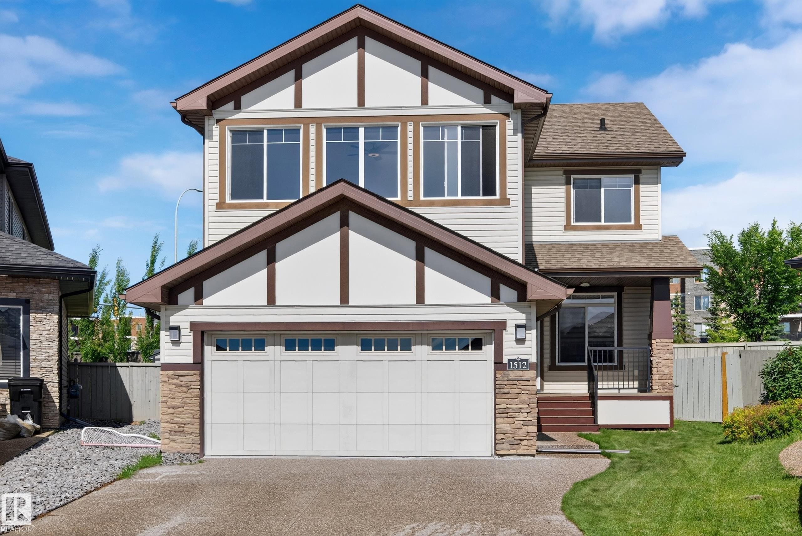 Craftsman-style exterior featuring a prominent two-car garage with paneling and window accents - 1512 Cunningham Cape, Edmonton, AB