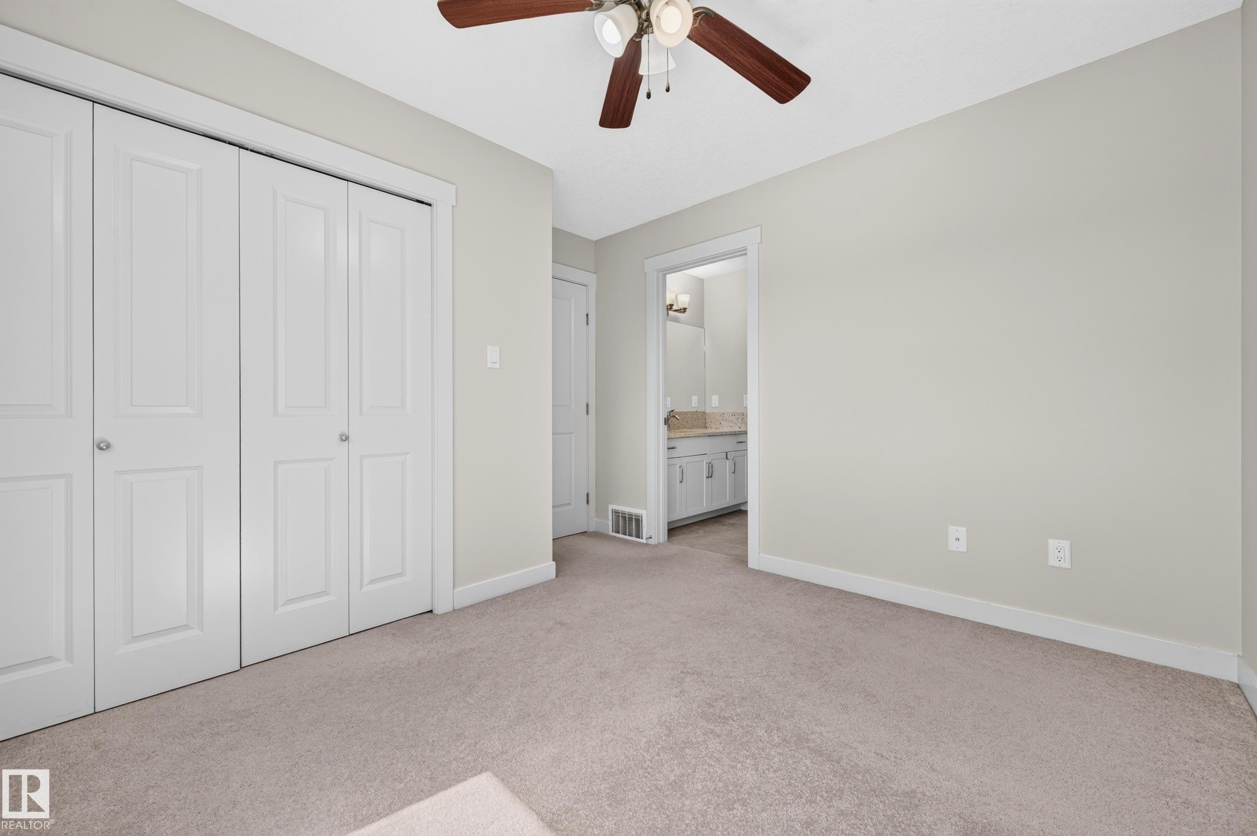 Neutral-toned carpeting throughout this room, featuring a ceiling fan with integrated lighting - 1512 Cunningham Cape, Edmonton, AB