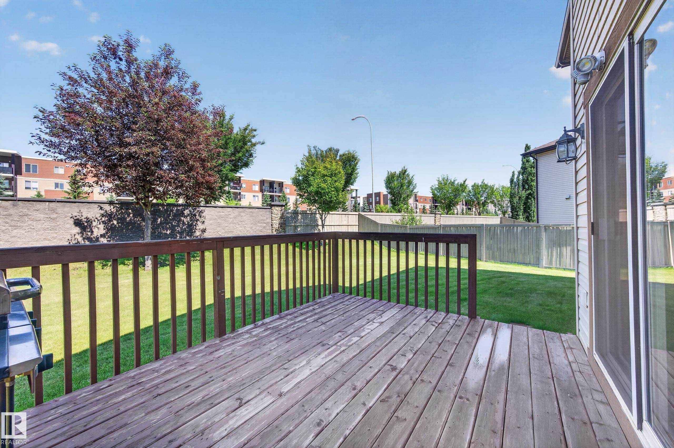 Exterior wood deck with railings and a sliding glass door - 1512 Cunningham Cape, Edmonton, AB
