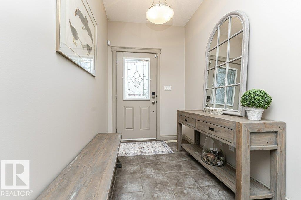 Entryway featuring a decorative front door with leaded glass, tile flooring, and a flush mount ceiling light - 15 175 Mcconachie Drive, Edmonton, AB