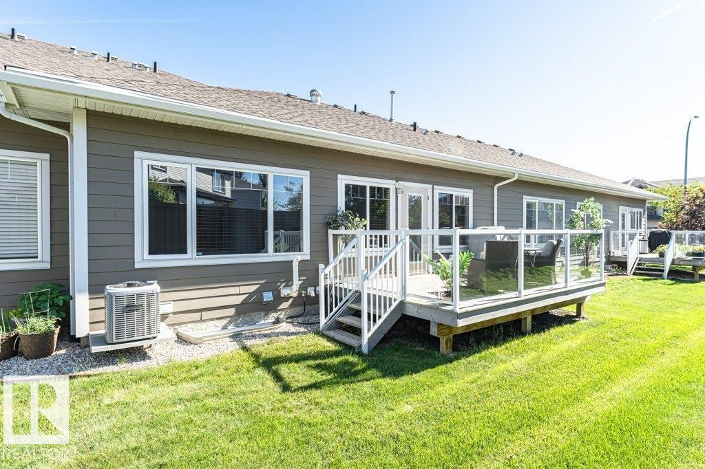 Expansive green lawn bordering a residence with siding exterior - 15 175 Mcconachie Drive, Edmonton, AB