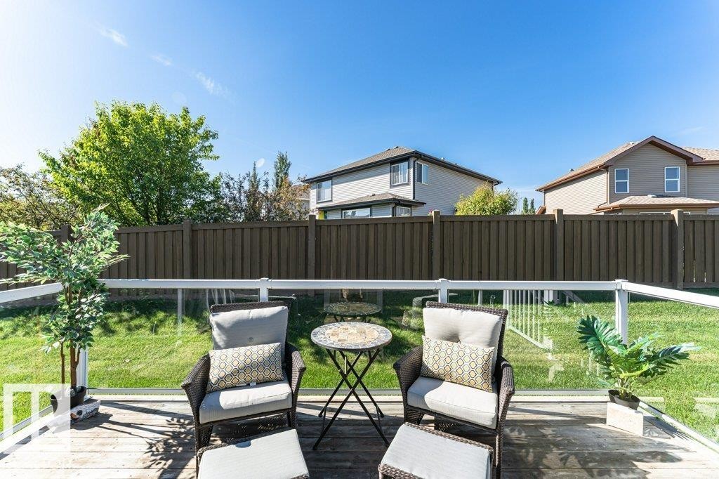 Expansive wood-finish deck featuring a clear glass and white railing - 15 175 Mcconachie Drive, Edmonton, AB