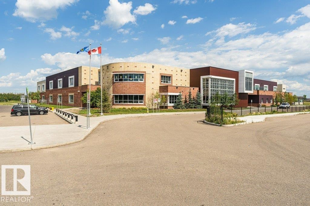 Contemporary commercial building featuring a multi-textured facade with brick, stucco, and dark paneling - 15 175 Mcconachie Drive, Edmonton, AB