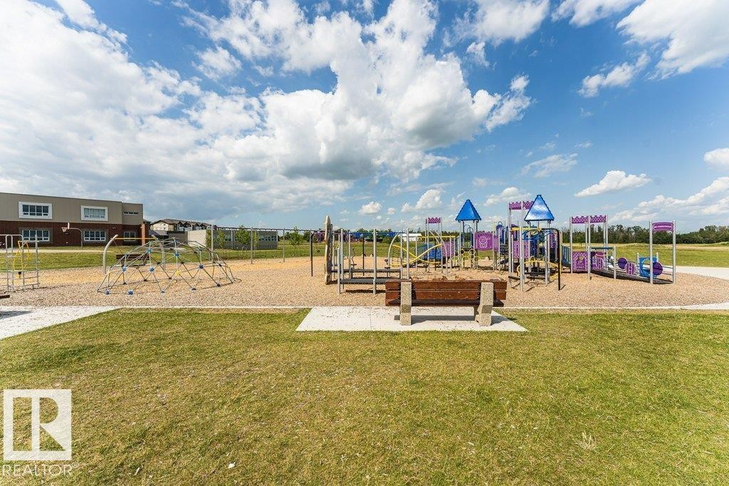 Expansive outdoor recreation area featuring a large playground with multiple structures, including slides and climbing apparatus - 15 175 Mcconachie Drive, Edmonton, AB