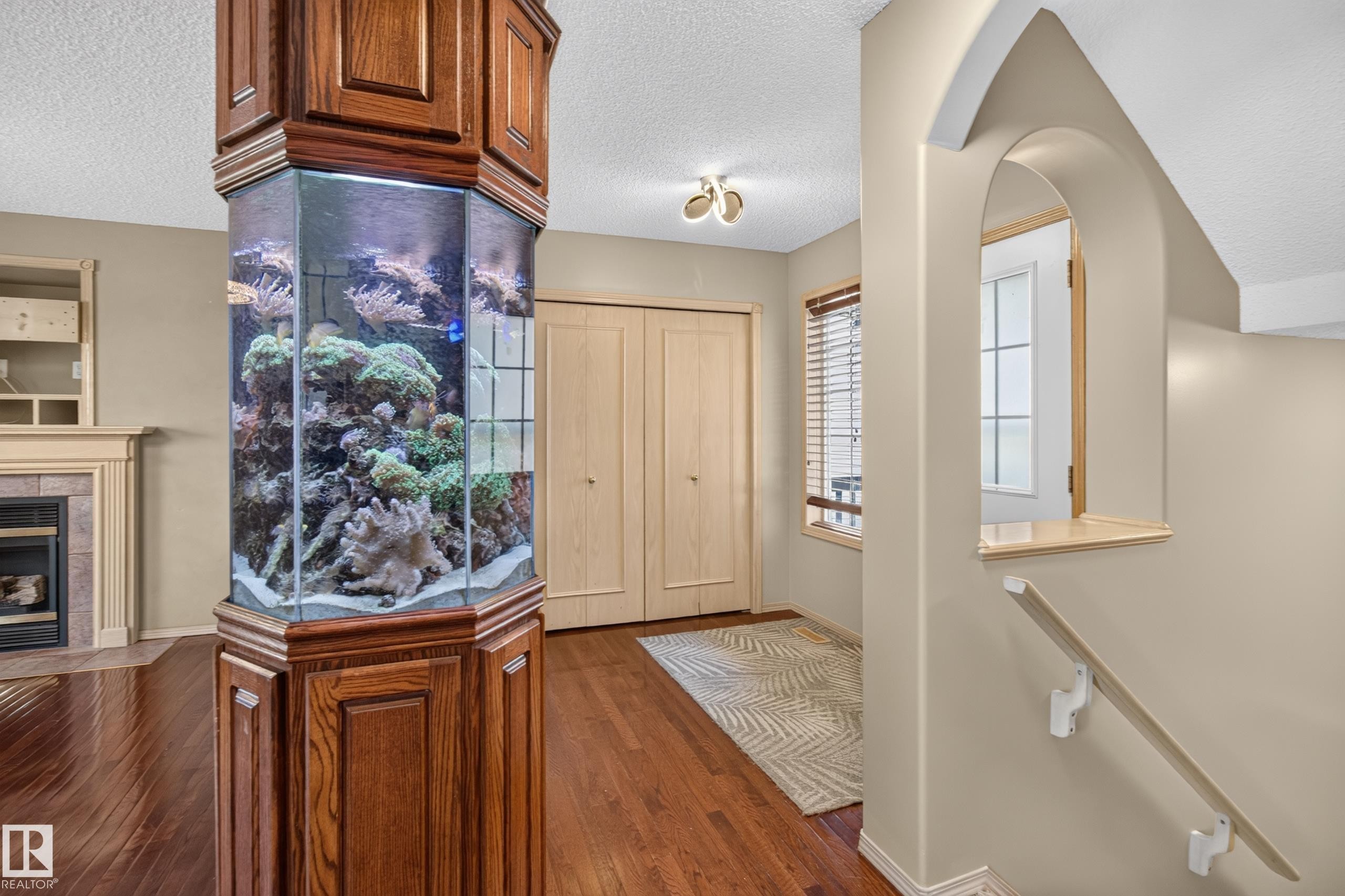 Built-in hexagonal aquarium with custom wood cabinetry - 13406 32A Street, Edmonton, AB