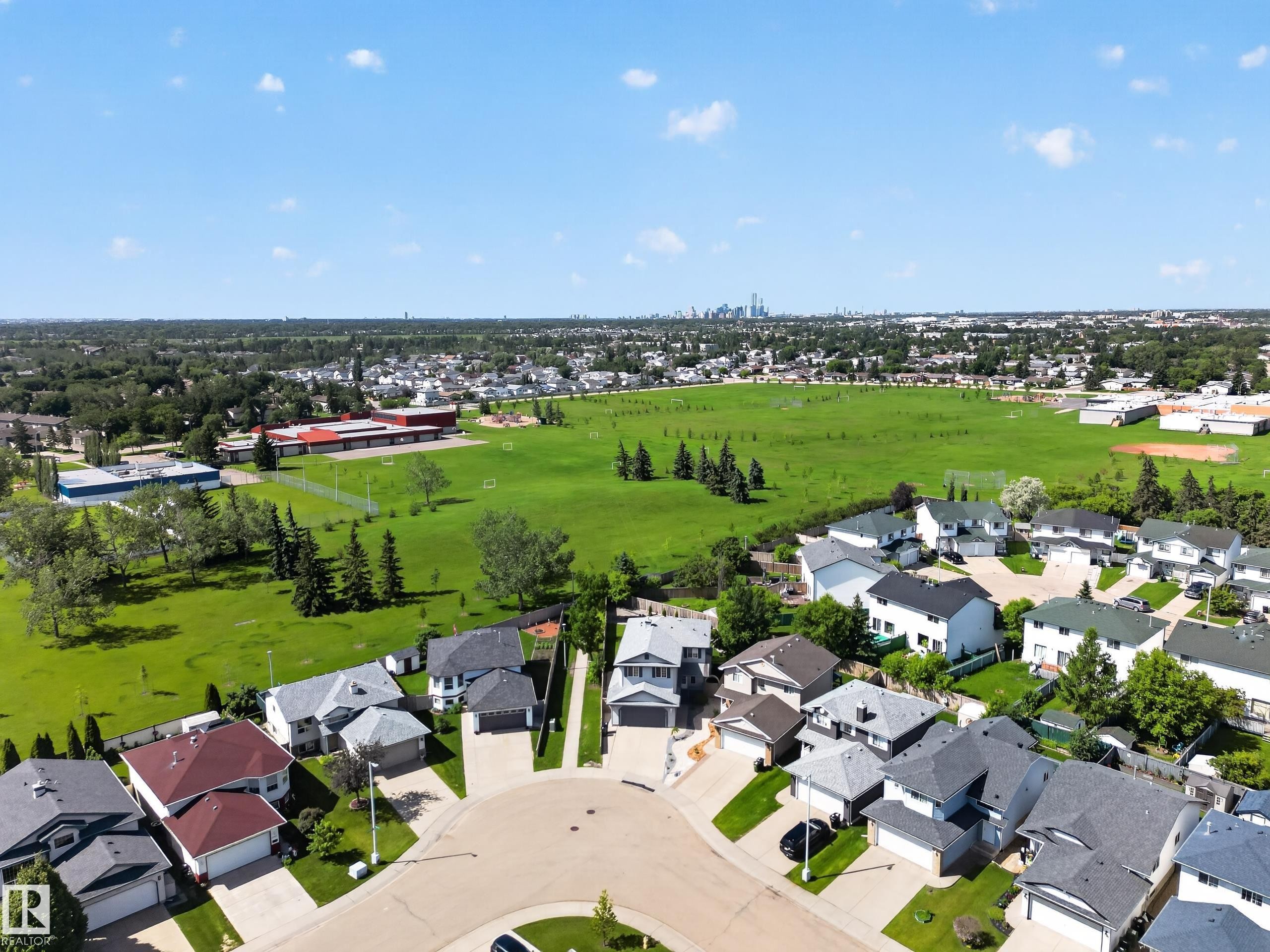 Residential neighborhood featuring a cul-de-sac, adjacent green space, and distant city skyline - 13406 32A Street, Edmonton, AB