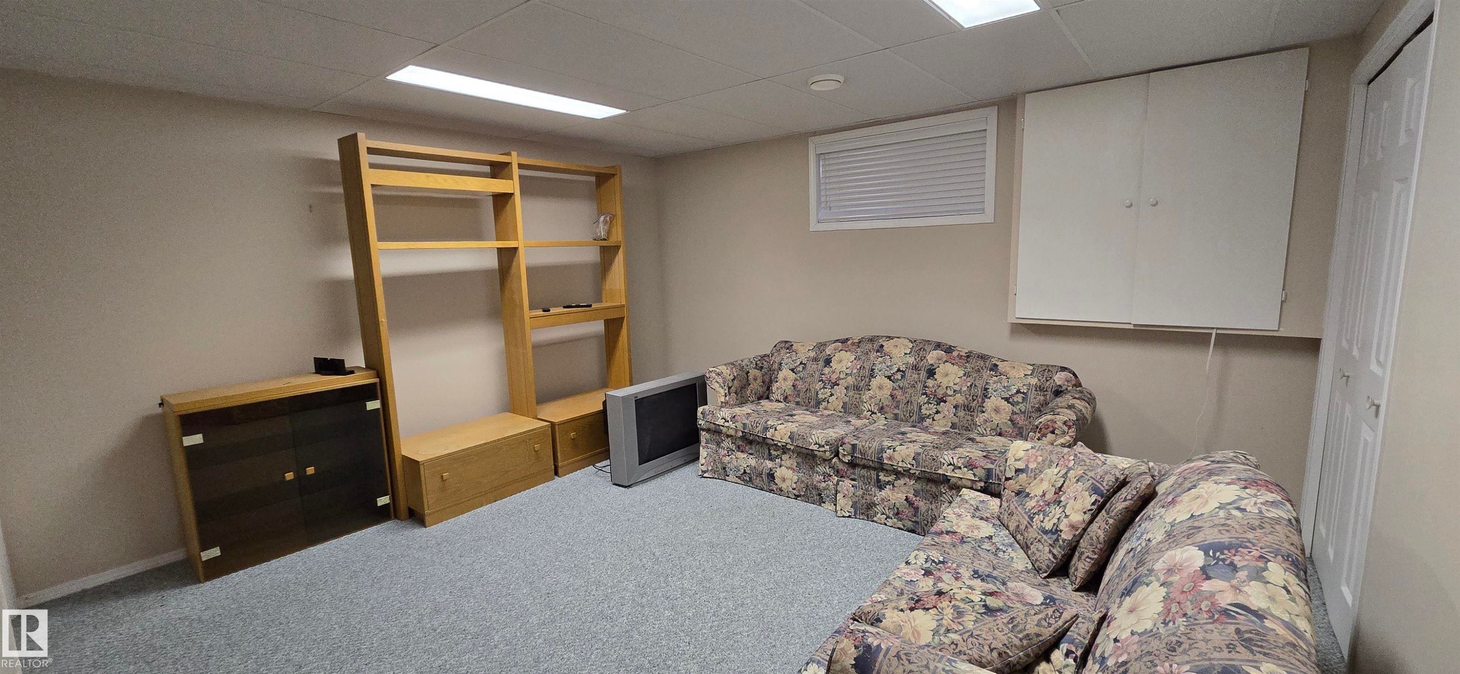 Carpeted room with neutral wall tones and a drop ceiling - 4734 54A Avenue, Vegreville, AB - Indoor Photo Showing Basement