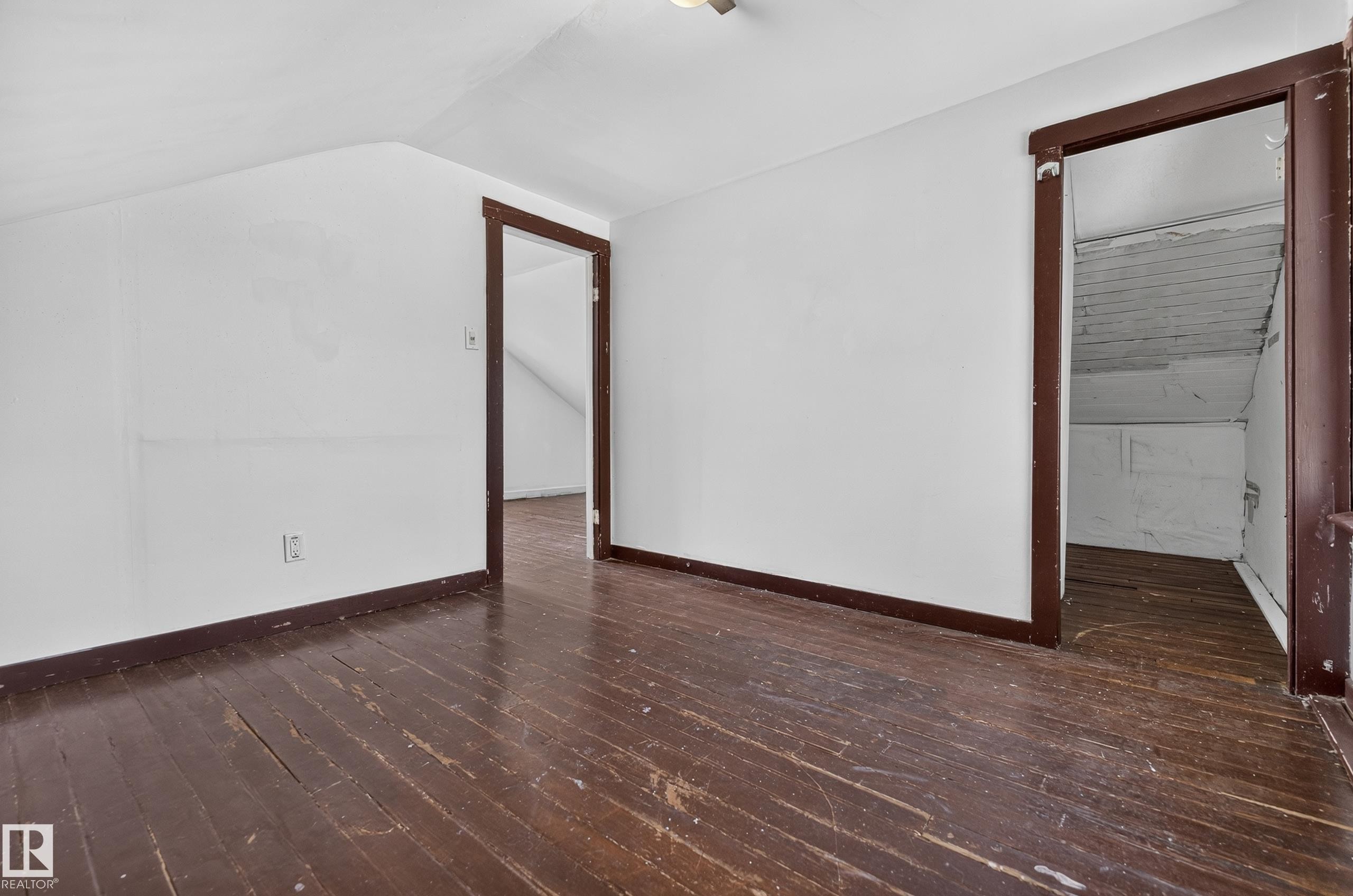 Spacious attic room with white painted walls and wood-finish flooring - 11708 79 Street, Edmonton, AB
