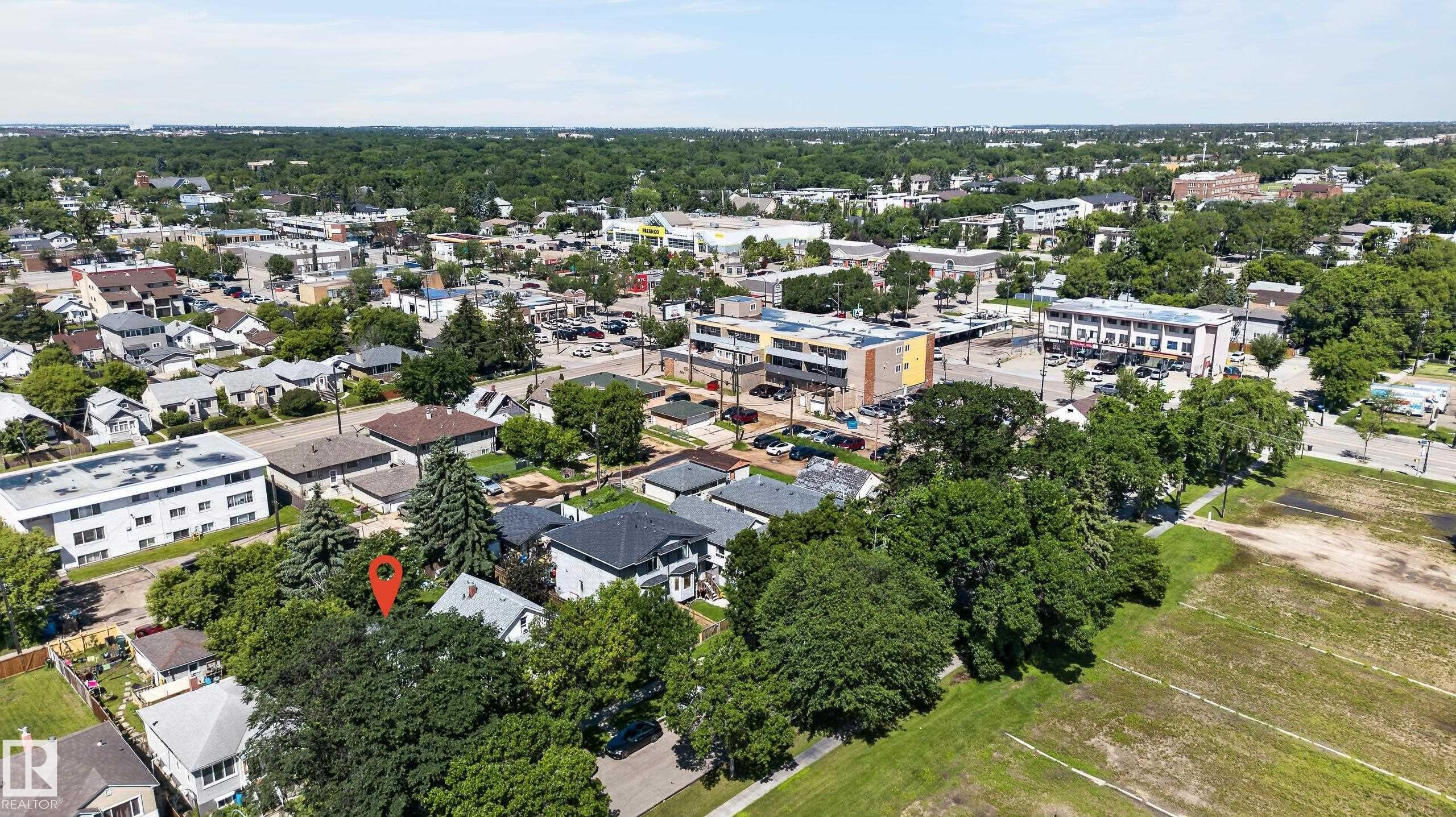 Aerial overview showcasing a residential property amidst a tree-lined neighborhood - 11708 79 Street, Edmonton, AB