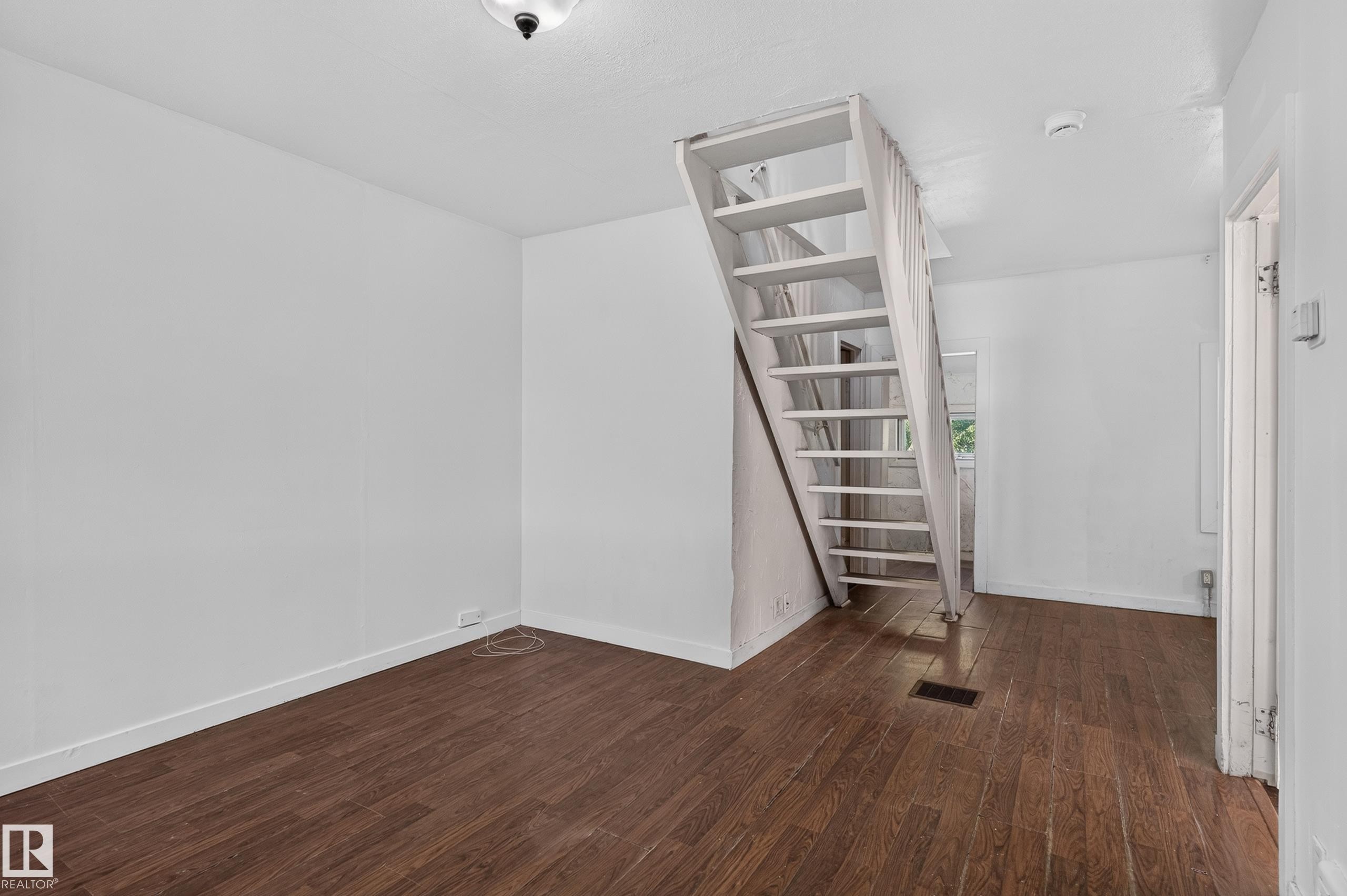 Staircase featuring open risers and painted wood construction - 11708 79 Street, Edmonton, AB